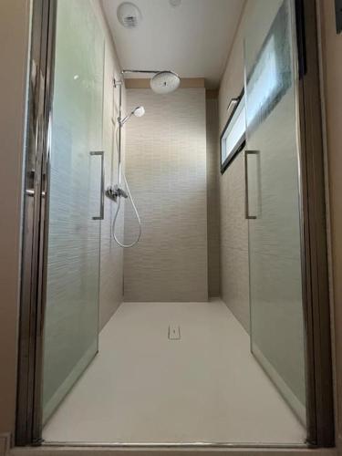 une salle de bain avec une douche avec une porte vitrée dans l'établissement Villa moderne avec piscine, à Sainte-Foy-lès-Lyon