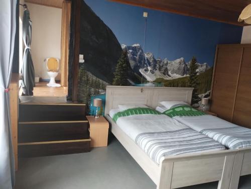 - une chambre avec un lit orné d'une fresque murale représentant la montagne dans l'établissement Auberge Hôtel chambre Tout Confort B-B et Restaurant Les Colombes, à Sugny