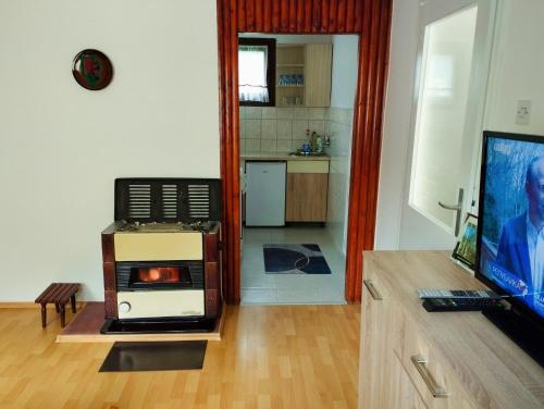 ein Wohnzimmer mit einem TV und einer Küche in der Unterkunft Vikendica Mia Balkana in Mrkonjić Grad