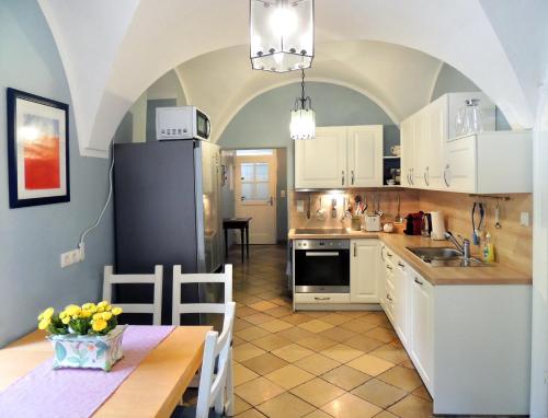 una cocina con armarios blancos y una mesa con comedor. en Wohnung im Schlösschen, en Lichtenfels