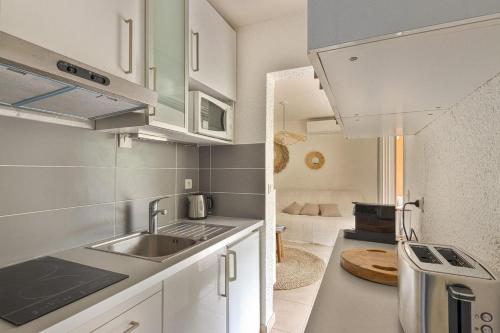 une petite cuisine avec un évier et une cuisinière dans l'établissement Joli appartement tout équipé, plage et centre 200m, à Cavalaire-sur-Mer