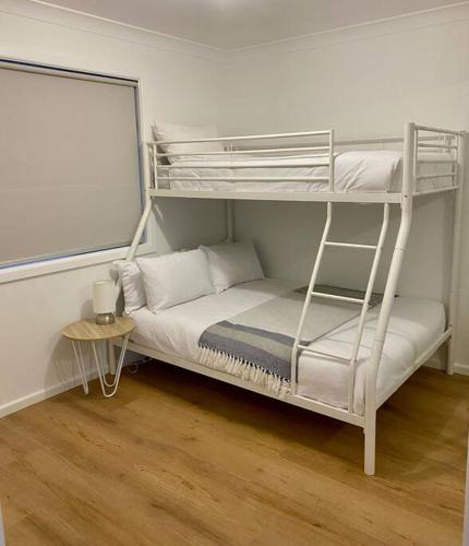a bedroom with a bunk bed and a table at Berridale Alpine Retreat in Berridale
