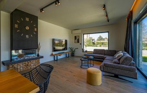 a living room with a couch and a clock on the wall at Villa Mia Stella in Štanga
