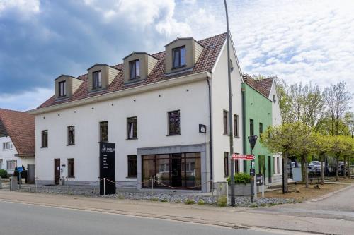 a large white building on the side of a street at Hotel de Boskar Houthalen in Houthalen-Helchteren