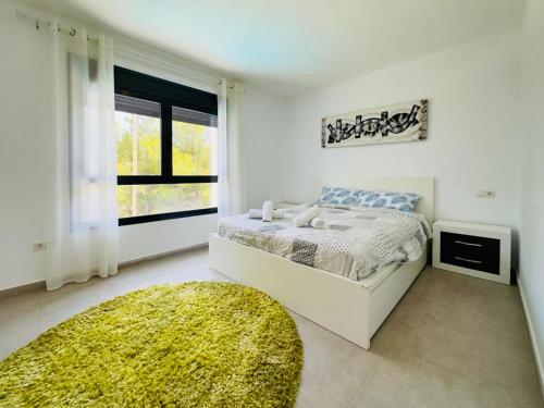 biała sypialnia z łóżkiem i oknem w obiekcie Calpe villa lujo playa piscina jardin barbacoa ideal familias y grupos w mieście Calpe