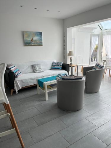 un salon avec un canapé et une table dans l'établissement Appartement les pieds dans l eau, à La Turballe