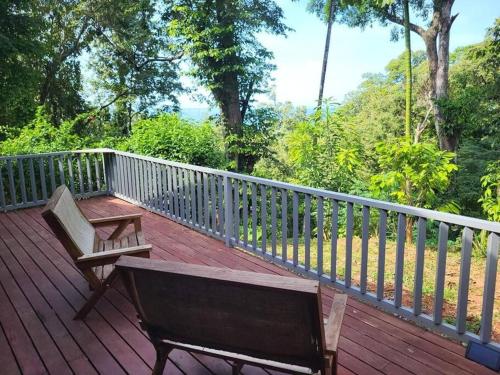 a wooden deck with a bench and a fence at Casa MILUCO Maison privée vue sur mer in Puerto Viejo
