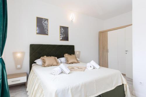 a bedroom with a large white bed with towels on it at Lions Suites in Split
