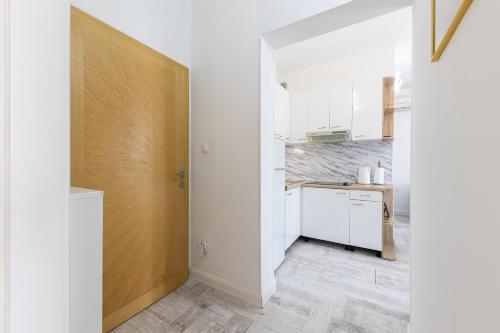 a kitchen with white cabinets and a wooden door at Lions Suites in Split