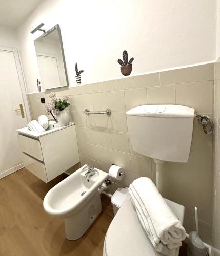 a white bathroom with a toilet and a sink at CINQUE TERRE MONEGLIA in Moneglia