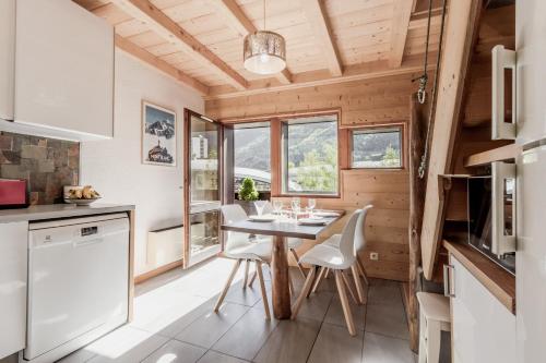 - une cuisine avec une table et des chaises dans une petite maison dans l'établissement Balcon du Mont-Blanc - Calme - Central, à Chamonix-Mont-Blanc