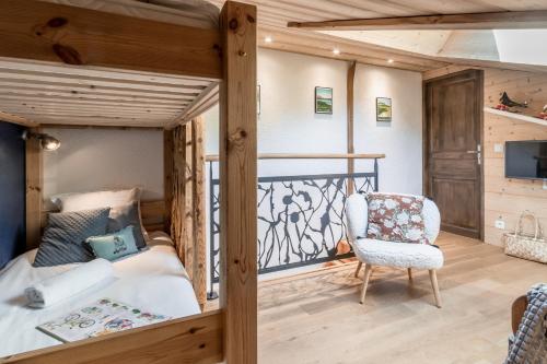 une chambre avec un lit superposé avec une chaise et une télévision dans l'établissement Balcon du Mont-Blanc - Calme - Central, à Chamonix-Mont-Blanc