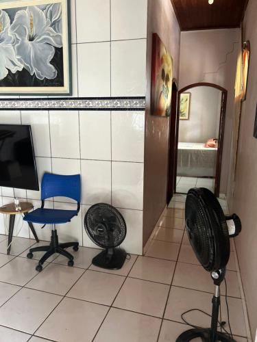 um quarto com uma ventoinha, uma cadeira e um espelho em Casa mobiliada - Rondônia Rural Show em Ji-Paraná