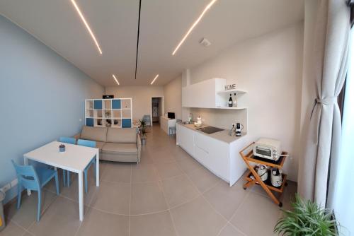 a kitchen and living room with a couch and a table at Al Ventisei - Azzurro in Treiso