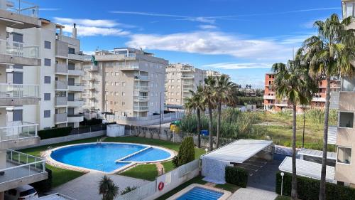 an apartment with a swimming pool and buildings at Apartamento Playa de Daimuz in Daimuz