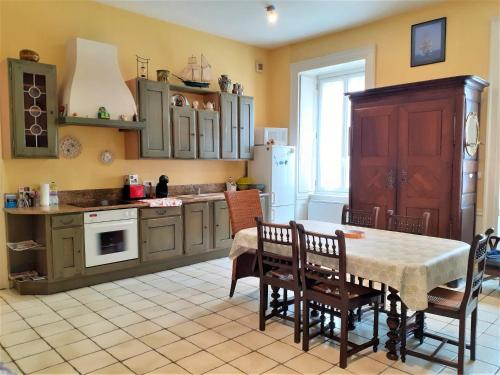 une cuisine avec une table, des chaises et un réfrigérateur dans l'établissement L'Asfeld, à Saint-Malo