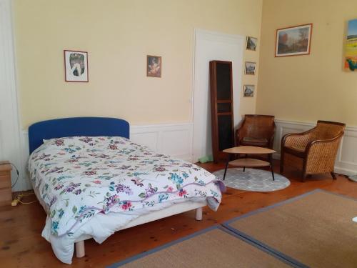 une chambre avec un lit et une chaise dans l'établissement L'Asfeld, à Saint-Malo