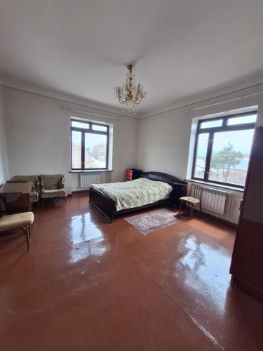 ein Schlafzimmer mit einem Bett und einer Couch und Fenstern in der Unterkunft Appartment in Gyumri in Gjumri
