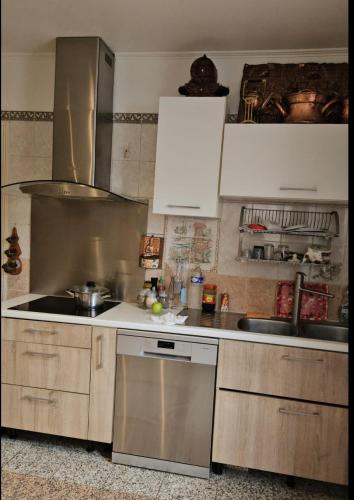 une cuisine avec un évier et une cuisinière four supérieur dans l'établissement Adorais, à Drancy