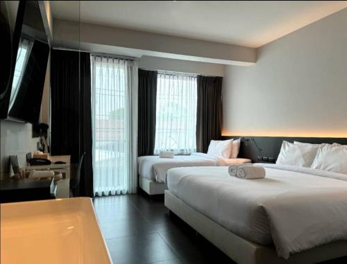 um quarto de hotel com duas camas e duas janelas em POR Arak em Chiang Mai