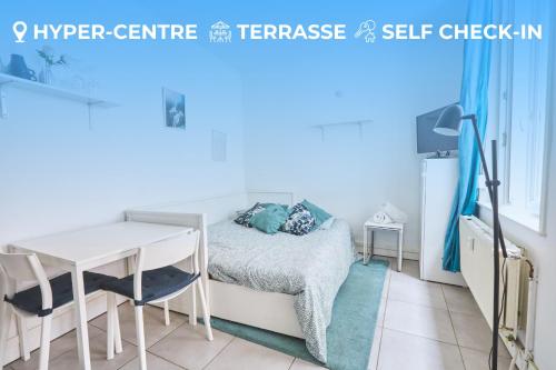 a small bedroom with a bed and a table at Studio charmant Lille Centre in Lille