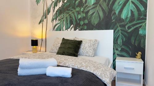 - une chambre avec un lit et du papier peint tropical dans l'établissement Parkcity Katowice Bogucice, à Katowice