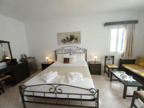 - une chambre avec un grand lit et un canapé dans l'établissement Venikouas Hotel, à Platis Gialos