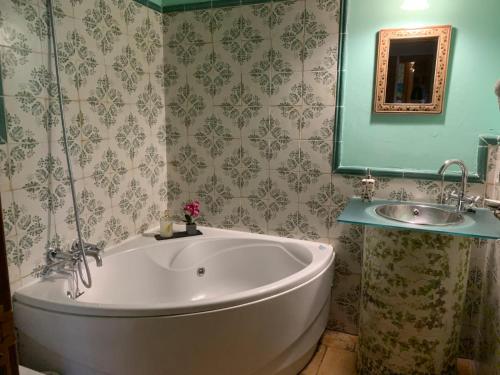 a bath tub in a bathroom with a sink at Posada Restaurante Fuenteplateada in Collado Hermoso