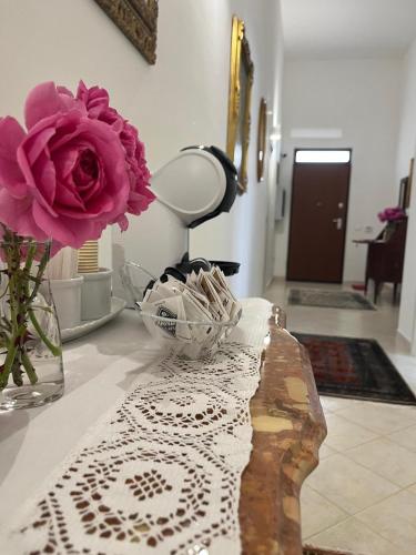 a vase with a pink flower on a table at Loredana Affittacamere in Vittoria