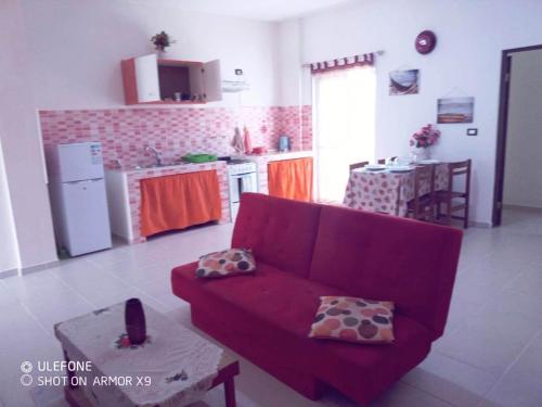 un soggiorno con divano rosso e una cucina di aparthotelboavistacom a Sal Rei