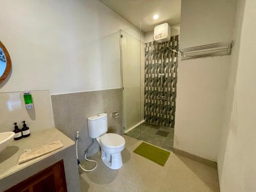 une salle de bain blanche avec toilettes et douche dans l'établissement Luana Villa Ubud, à Ubud
