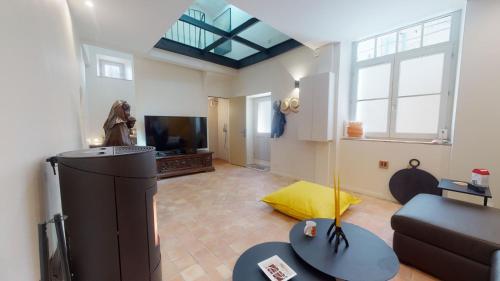 a living room with a couch and a tv at La tour de Grignan in Grignan