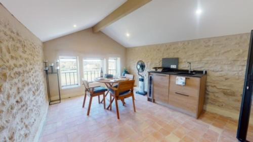a kitchen and dining room with a table and chairs at La tour de Grignan in Grignan