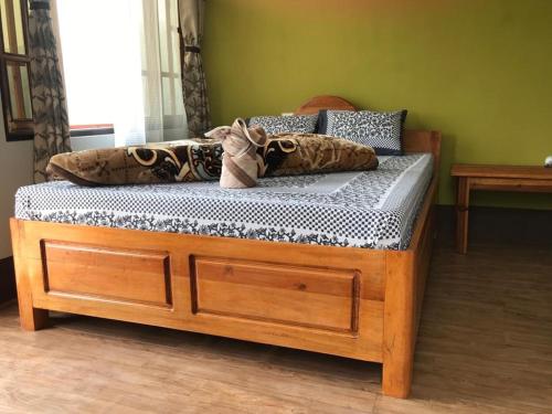 a wooden bed with pillows on it in a room at Khee Homestay in Kurseong
