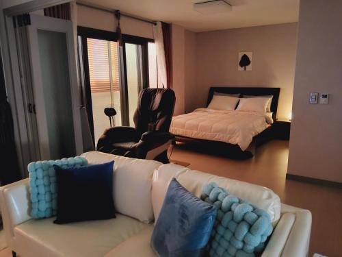 a living room with a couch and a bed at Woljeong Comfort Stay in Jeju
