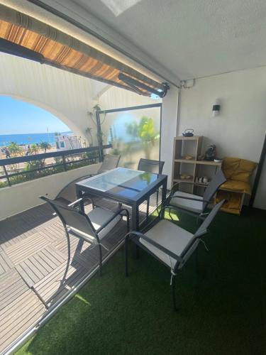 d'une table à manger et de chaises sur un balcon donnant sur la plage. dans l'établissement Aux terrasses de la mer, à Cannes