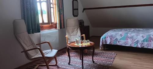 a room with a table and chairs and a bed at Domaine de la cure in Curgy