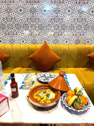 a table with a plate of food on it at Playa Del Sol Surf House in Tamraght Ouzdar