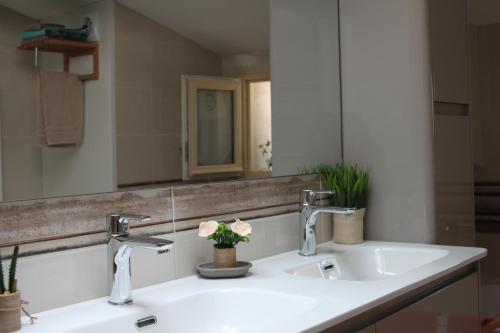 - un lavabo avec deux robinets et un miroir dans l'établissement Lourecantou, à Saint-Thibéry