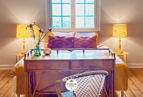 una stanza con una scrivania con un divano e due lampade di The Woodland Lodge Gisselfeld a Haslev