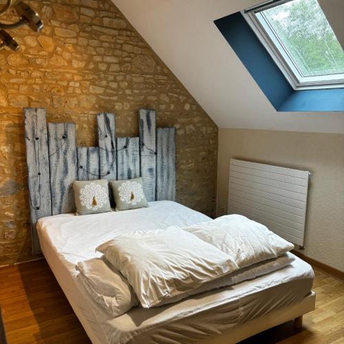 a bedroom with a bed with a brick wall at Grand gîte de caractère à la campagne in Fercé