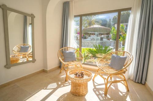 a room with three chairs and a large window at Kassandra Boutique Hotel in Oludeniz