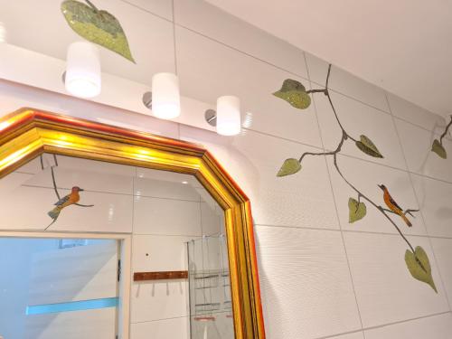 a bathroom with a mirror and birds on the wall at Żurawie gniazdo, elegancki zakątek w Puszczy Białowieskiej in Hajnówka
