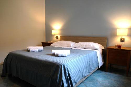 una camera da letto con un letto e due asciugamani di Gli Ulivi Apartment a Capaccio-Paestum