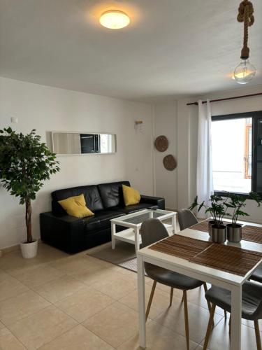 uma sala de estar com um sofá preto e uma mesa em Increíble apartamento en pleno centro de Arrecife em Arrecife