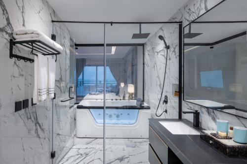 a bathroom with a shower and a sink and a tub at Braira Al Azizya Hotel & Resort in Al Khobar