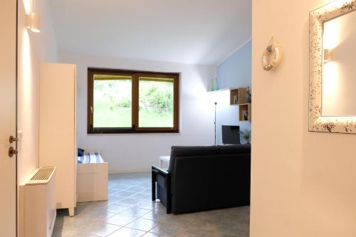 - un salon avec un canapé noir et un miroir dans l'établissement Gli Ulivi Apartment, à Capaccio-Paestum