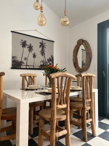 une salle à manger avec une table et des chaises blanches dans l'établissement Maison à deux pas des Dunes et de la plage-15mn du Vendée Globe, à Bretignolles-sur-Mer