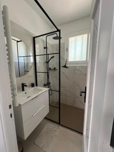 une salle de bain blanche avec une douche et un lavabo dans l'établissement Maison à deux pas des Dunes et de la plage-15mn du Vendée Globe, à Bretignolles-sur-Mer