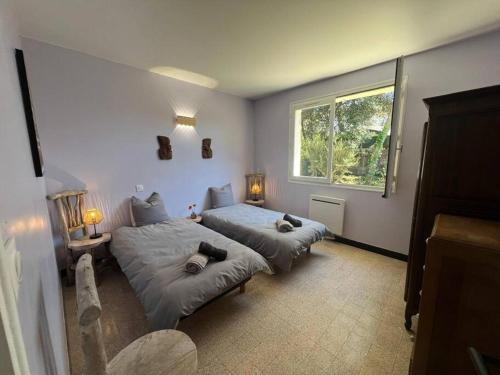 une chambre avec deux lits et une fenêtre dans l'établissement Maison à deux pas des Dunes et de la plage-15mn du Vendée Globe, à Bretignolles-sur-Mer